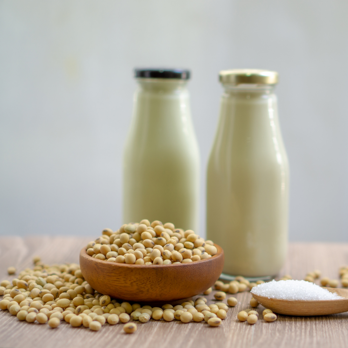 "Sojamilch in Glasflaschen mit frischen Sojabohnen – perfekte pflanzliche Alternative für eine gesunde Ernährung."