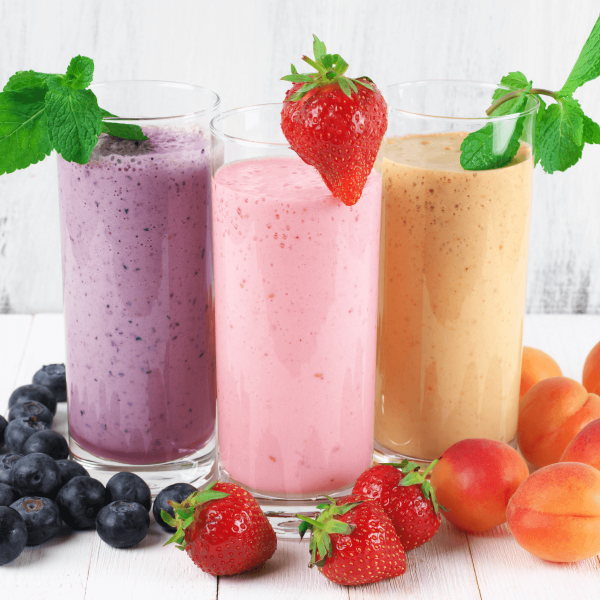 "Bunte Smoothies aus frischen Beeren und Früchten: Heidelbeer-Smoothie mit Minze, Erdbeer-Smoothie mit frischer Erdbeere und Aprikosen-Smoothie – gesund und erfrischend."