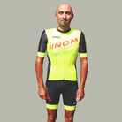 "Vorderansicht eines Radfahrers im gelb-schwarzen NOM-Training-Radtrikot mit Sportsfood-Logo, entworfen für Komfort und Performance."