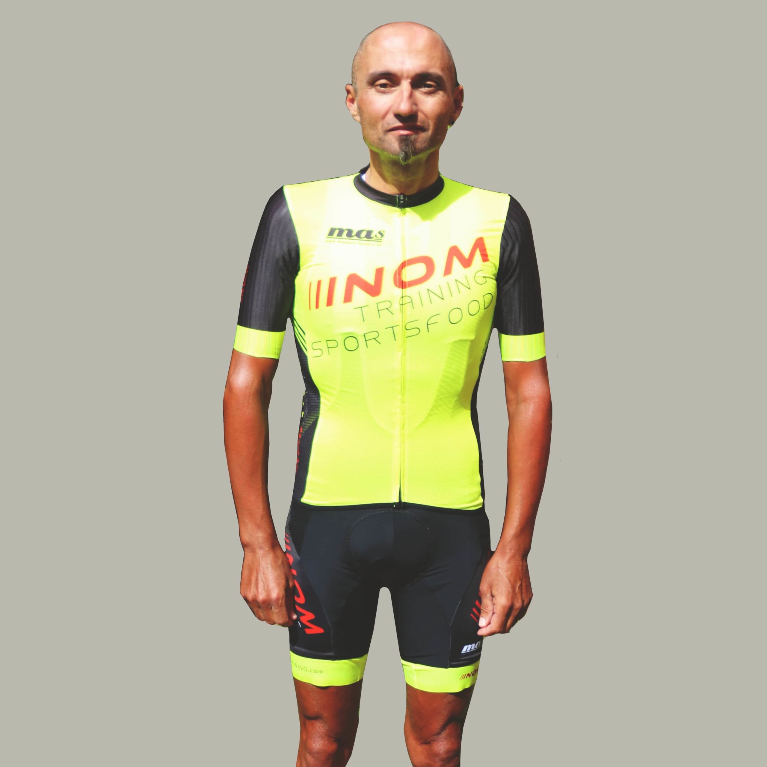 "Vorderansicht eines Radfahrers im gelb-schwarzen NOM-Training-Radtrikot mit Sportsfood-Logo, entworfen für Komfort und Performance."