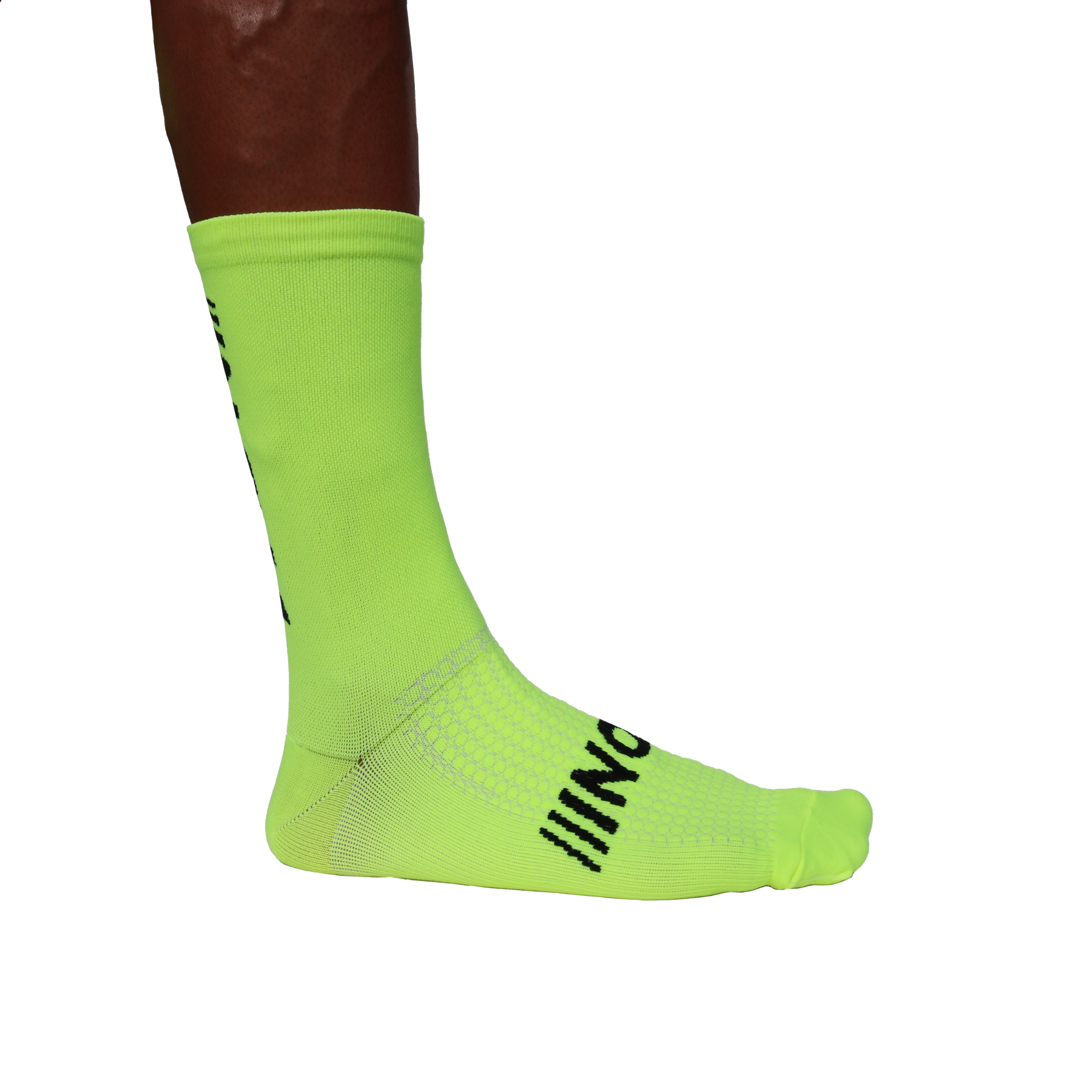 "Neon-grüne Sportsocken mit schwarzem NOM-Logo auf der Fußoberseite, getragen von einer Person, Seitenansicht der Füße."