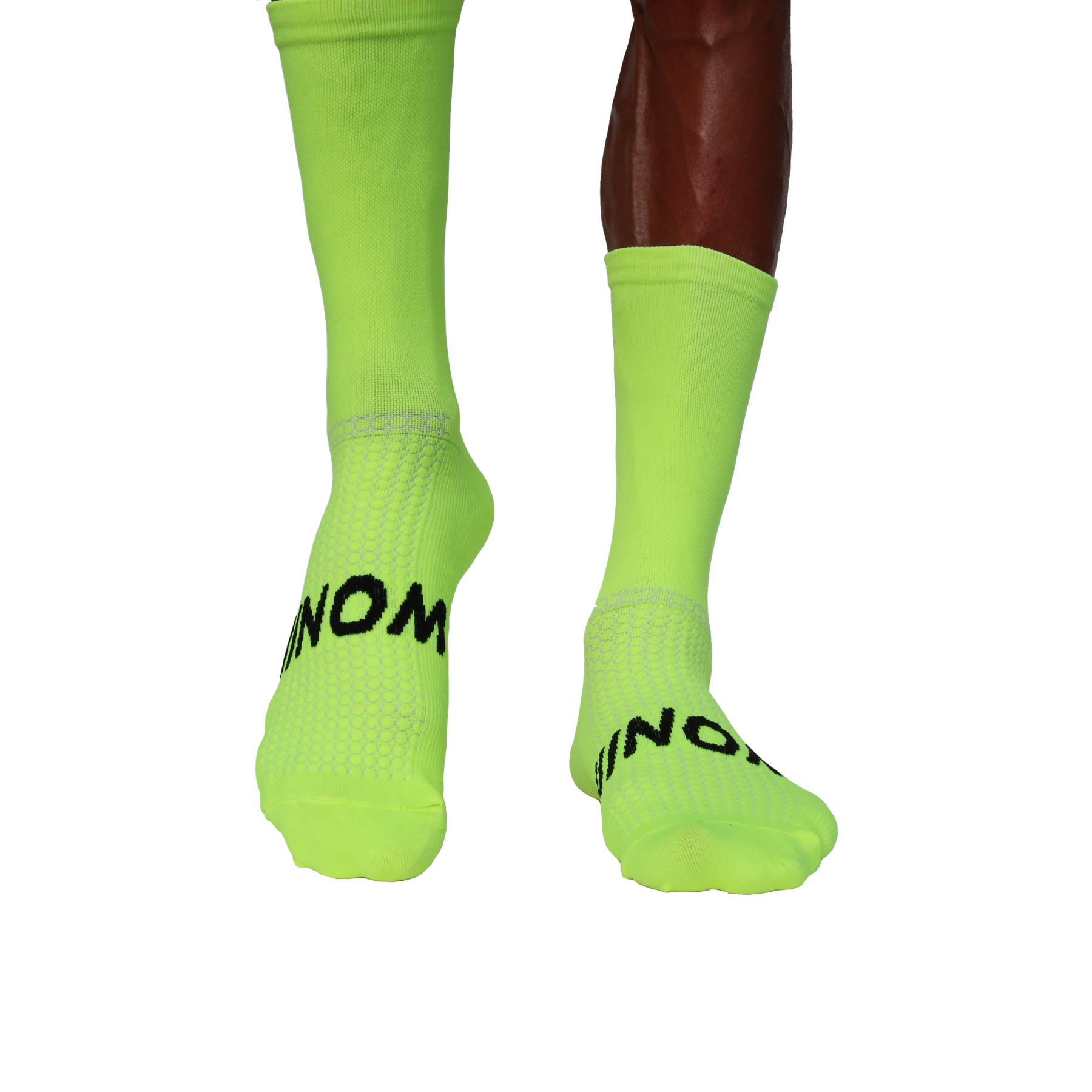 "Neon-grüne Sportsocken mit schwarzem NOM-Logo auf der Fußoberseite, getragen von einer Person, Vorderansicht der Füße."