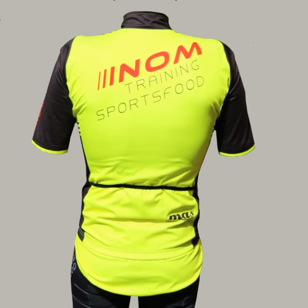 "Rückansicht einer leuchtend gelben NOM Training Sportsfood Radjacke mit schwarzen Ärmeln und praktischen Taschen."